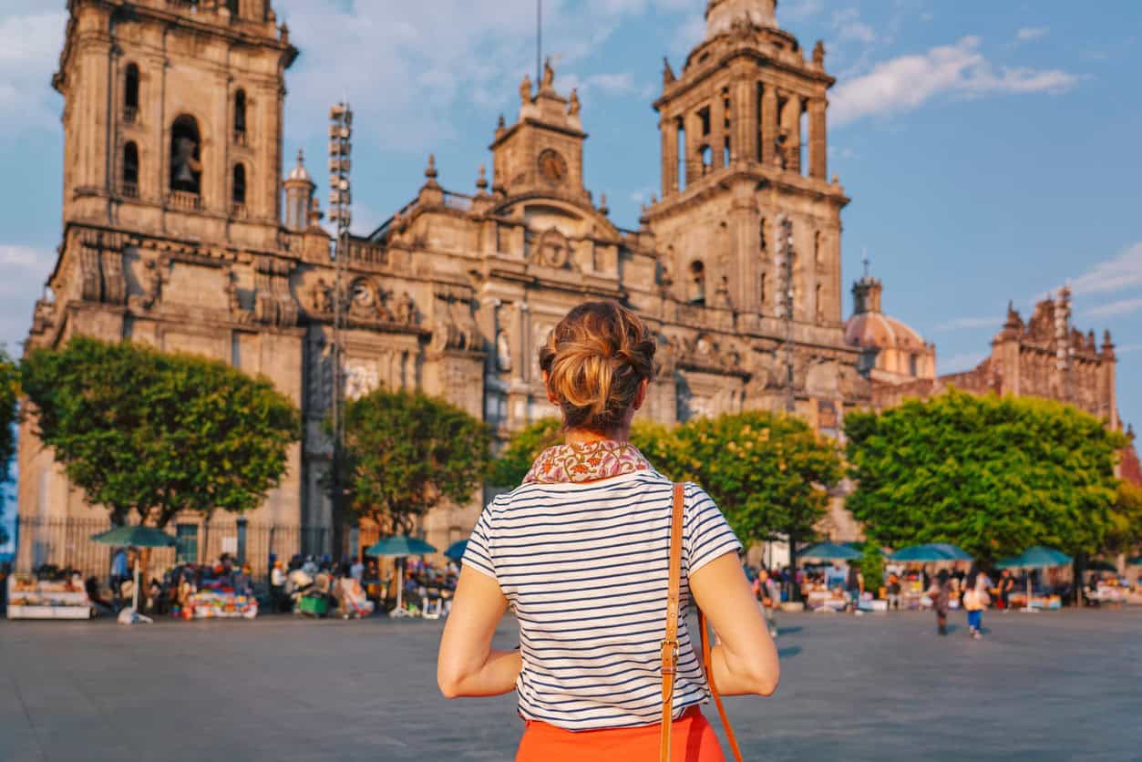 Traveler standing in Mexico City’s Zócalo facing the Metropolitan Cathedral on a sunny day