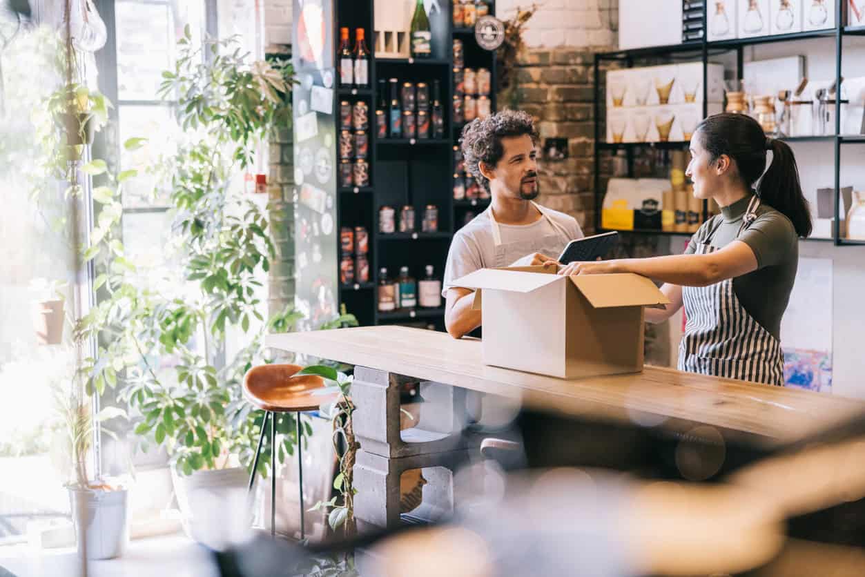 Two small business owners packing a customer order in a shop