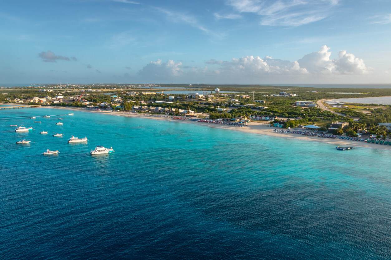 Aerial view of turquoise water, white-sand beach and small boats anchored off the coast in Turks and Caicos