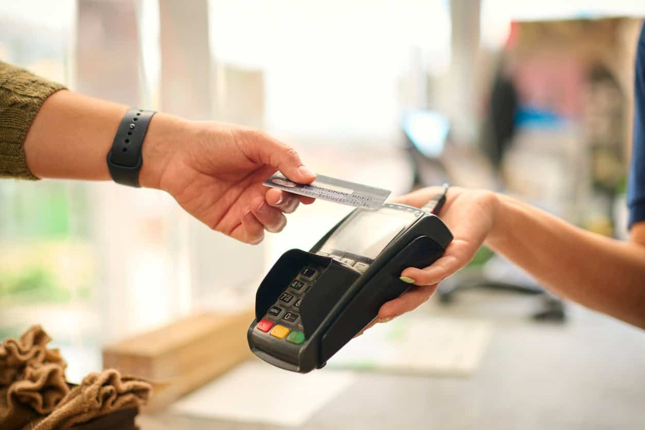 Customer paying for a purchase with a credit card on a POS payment terminal