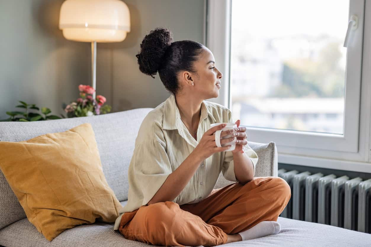 Woman relaxing at home considering which credit card best fits her lifestyle and financial needs