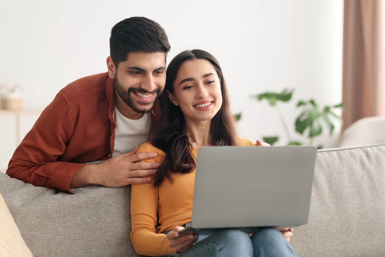 Couple using laptop together exploring travel rewards and points community benefits