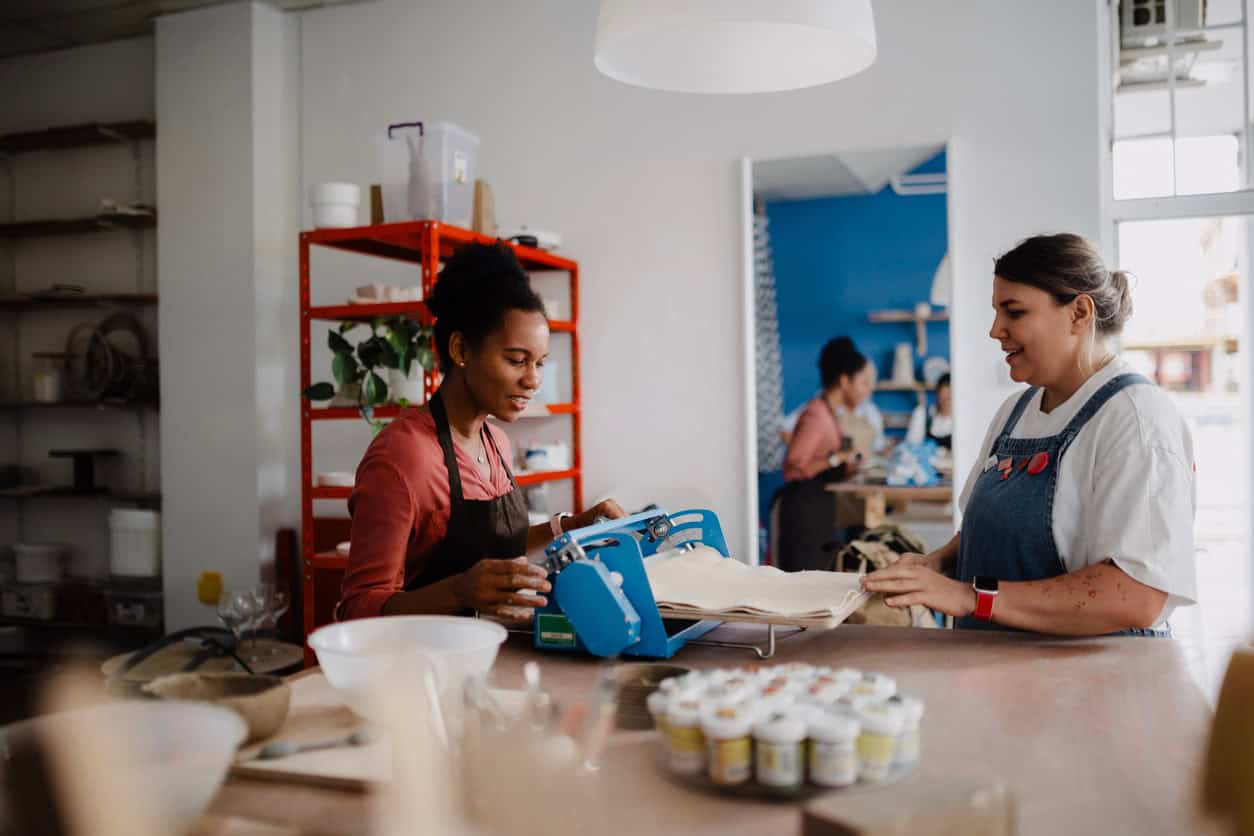 Small business owners working together in a bakery kitchen preparing food and managing daily operations