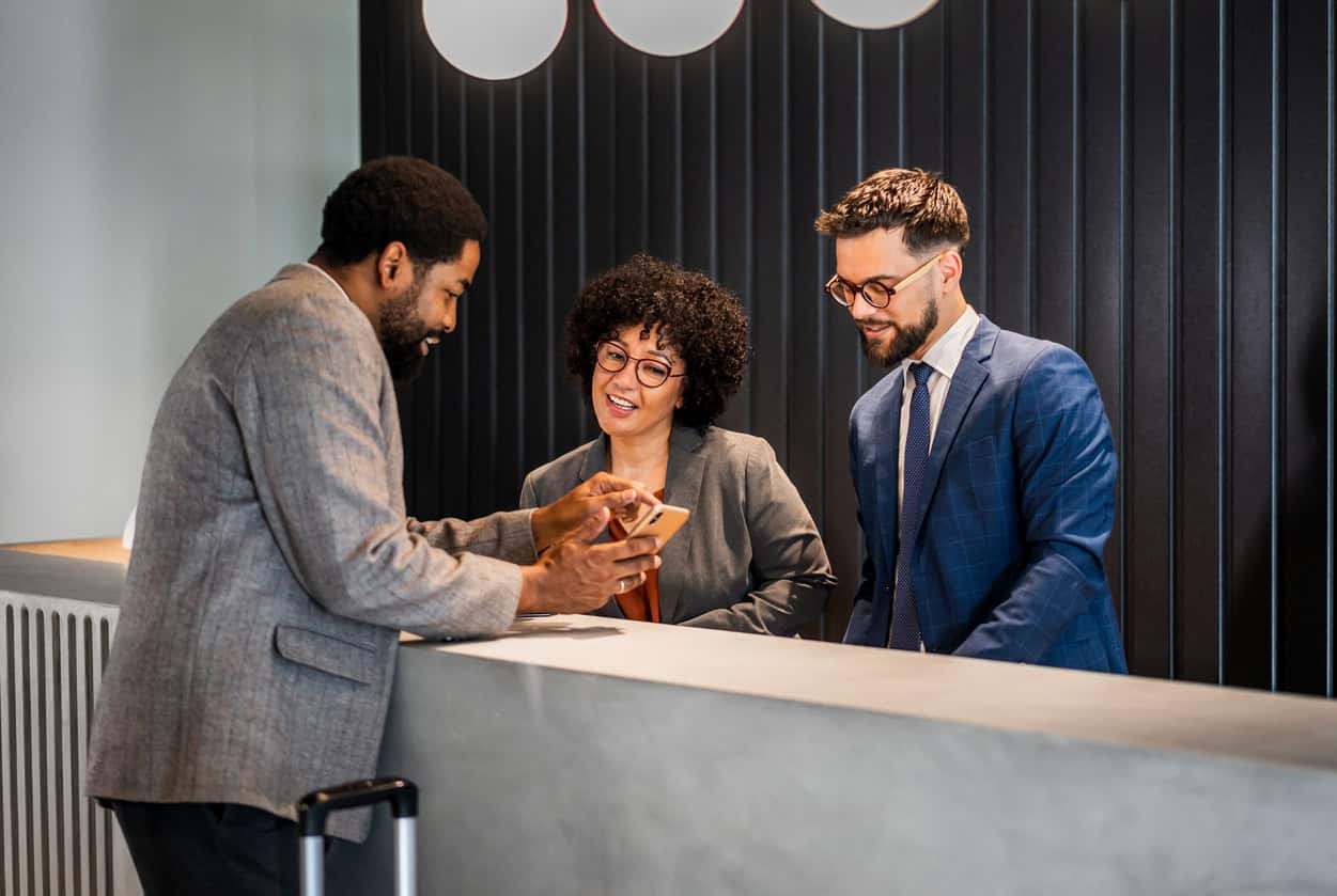Travelers checking in at a hotel front desk.