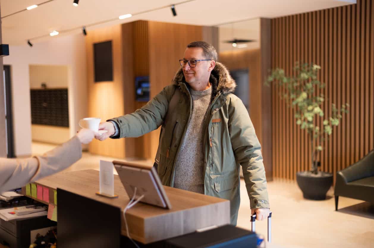 Traveler checking into a hotel with luggage.