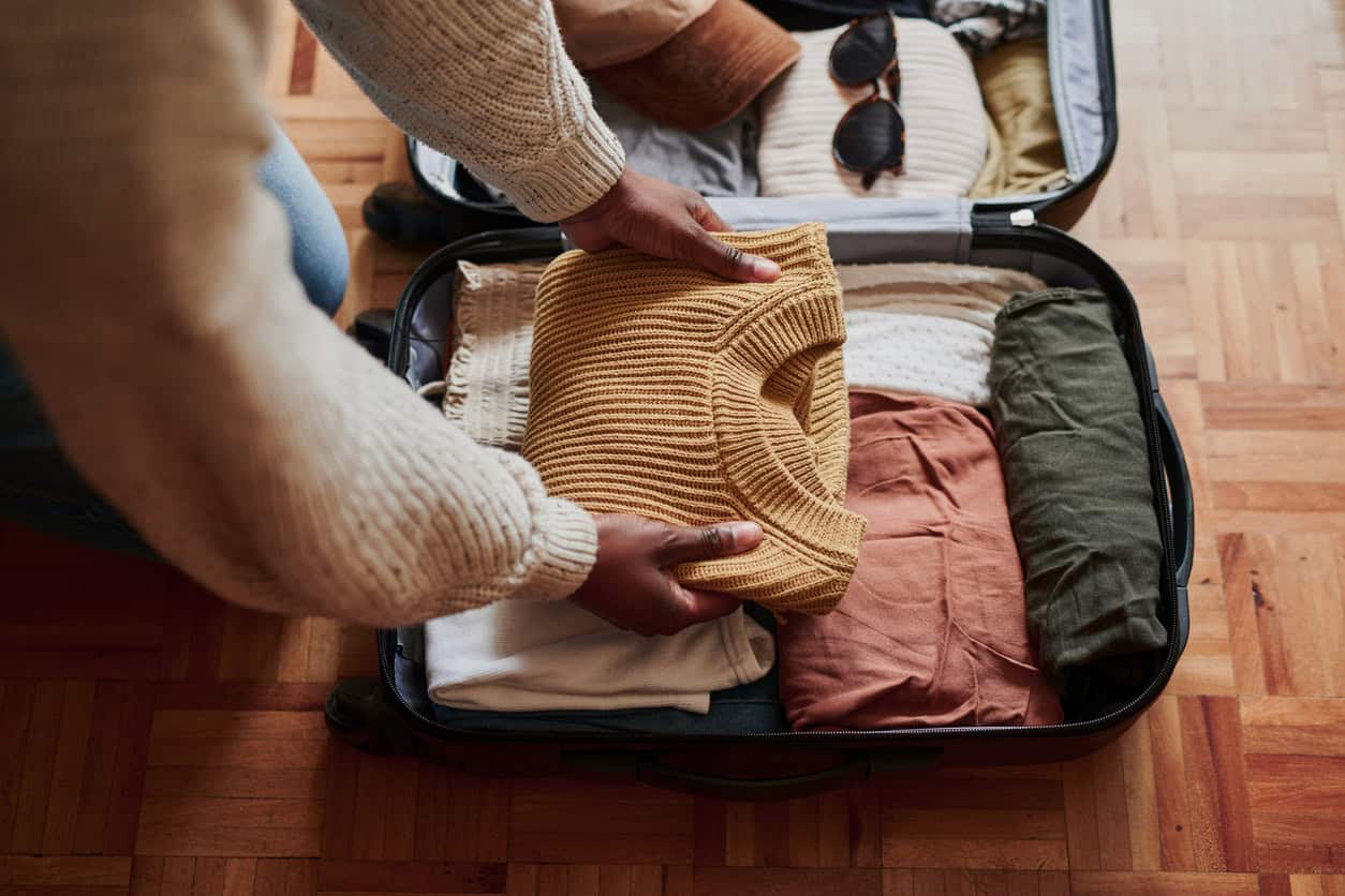 Packing a suitcase for a trip using miles earned from online shopping and credit card rewards.