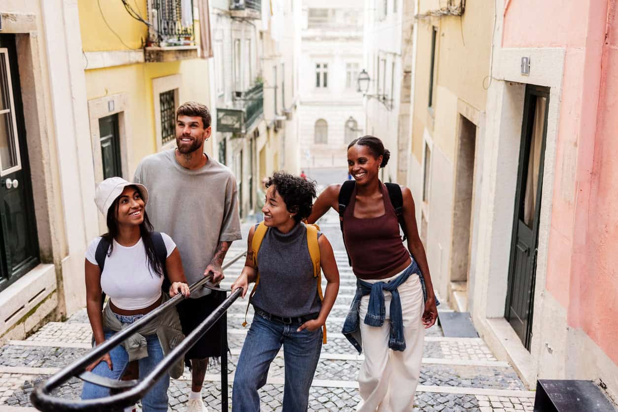 Group of travelers walking up a charming cobblestone street in a historic European city.