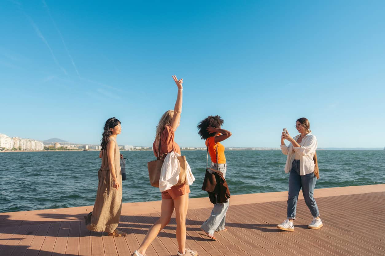 Group of tourists enjoying a sunny day by the waterfront while traveling.